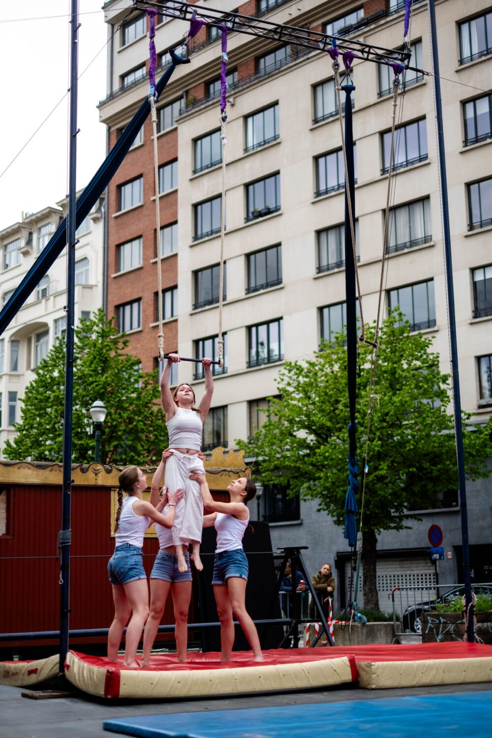 Photographie d'illustration : 4 jeunes réalise un porté sur une scène en extérieur.